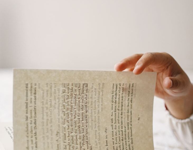 a person is reading a book on a bed