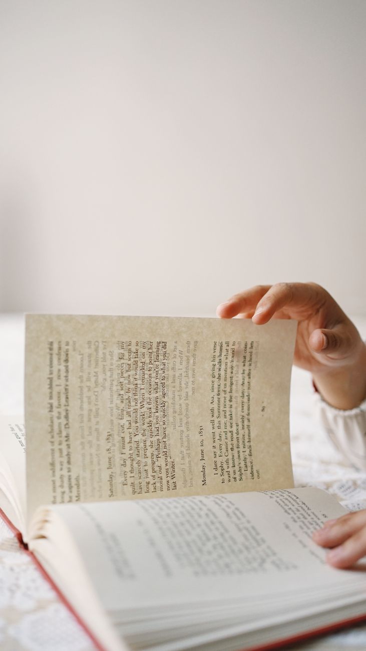 a person is reading a book on a bed