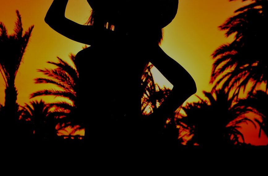 silhouette of a person wearing hat while posing at the camera