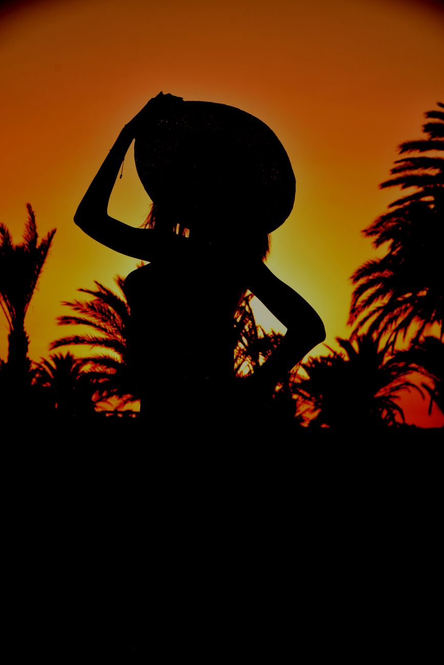 silhouette of a person wearing hat while posing at the camera